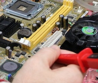 Tech working on a computer motherboard